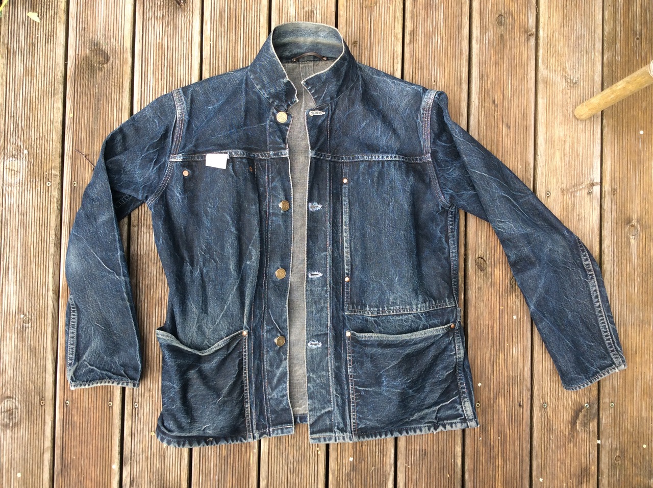 Worn denim jacket laid on a wooden deck